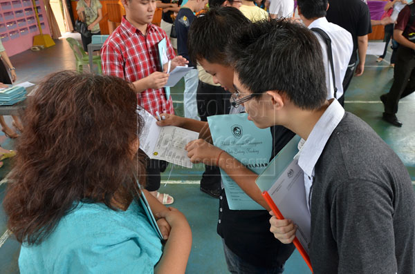 DOES IT TALLY? SMK Batu Lintang STPM students checking their result slips. — Photo by Hii Kheng Juong