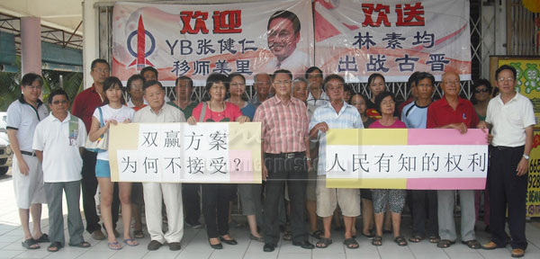 SWITCH DEMAND: DAP Miri members led by Fong (fifth left) in a banner protest asking for a swap between Miri and Kuching DAP candidates. 