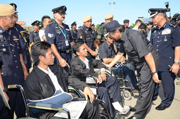 Musa (second right) talking to policemen who were wounded in Ops Daulat as Hamza (right) looks on. 