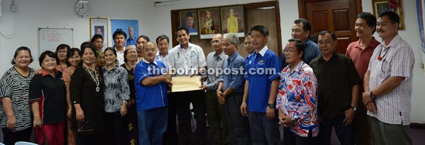 Peter (twelfth left) hands over the resolution to Dennis. 