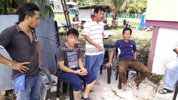 Chin (seated left) peering at the burnt down remnants of the house.