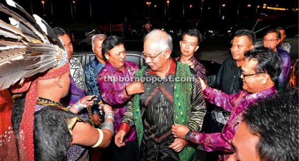 Mawan and Nanta (right) help Najib put on a specially made ‘pua kumbu’ motif vest.  