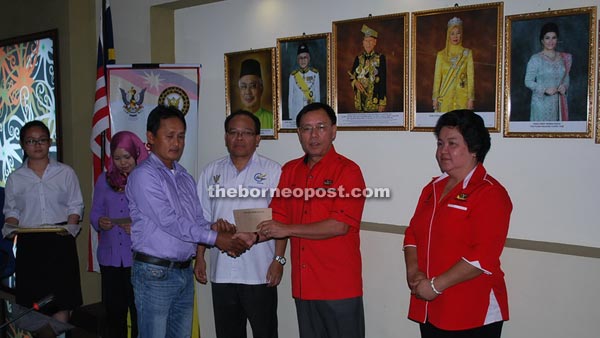 Rundi (second right) presents MRP cheque to one of the recipients as others look on.