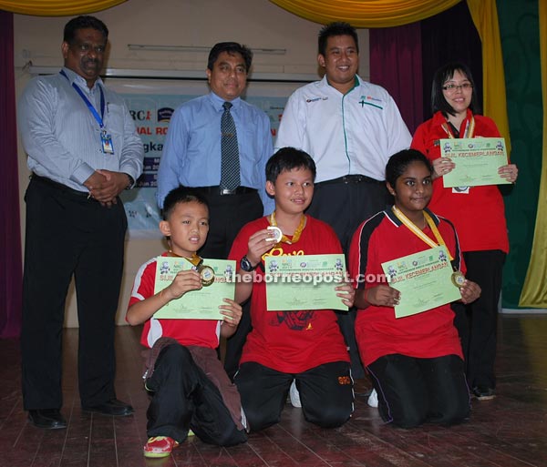 Muin (standing second left) and other guests posing with the winners of the primary school circuit category.