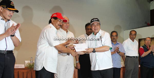 Awang Tengah (fourth right) handing over the cheque to Musa Aman, witnessed by Najib (third left). — Penerangan photo      