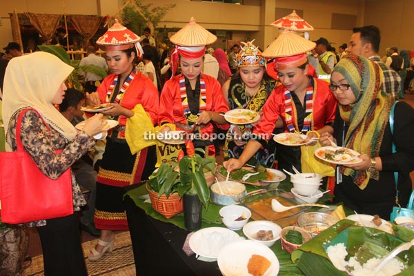 Beautiful ladies dressed in traditional costumes enjoy the food.