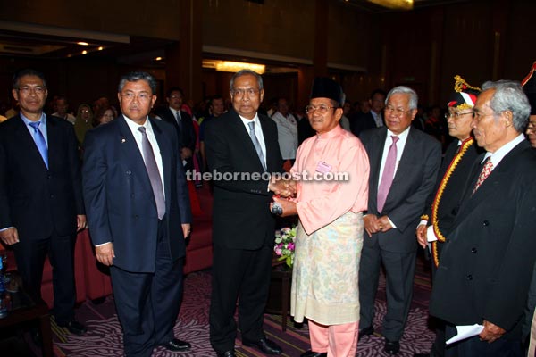 Adenan (second left) receiving the scroll from Temenggong Chek Bujang after community leaders recited their pledge to serve the people. With them are Morshidi (left) and Manyin (fourth left). — Photos by Chimon Upon 