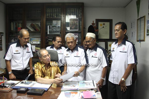 Wan Junaidi discusses a point with Ex-Policemen Association Kuching branch chief Samson Michael Juan. 