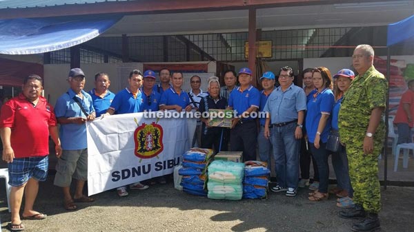 Tengku (seventh right) hands over the donation to Tuai Rumah Meruan in Nanga Tada, Kanowit.