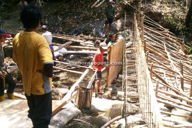 Villagers helping to construct the dam, which is now about 50 per cent complete.