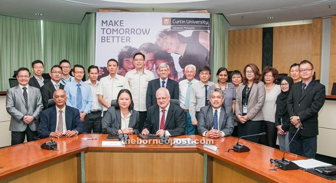 (Seated from second right) Mienczakowski, Peing and others during the group photo following the MoU signing.