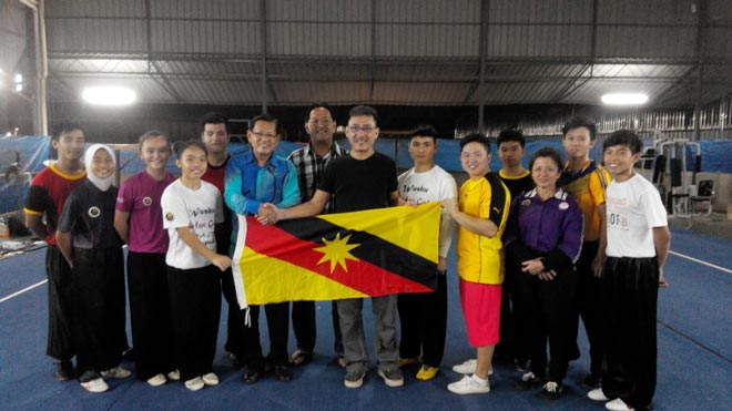 Lee (sixth left) hands over the state flag to team manager Allen Wong (seventh right) while WFS deputy president Ting (seventh left), coach Ling (third right) and the athletes look on.