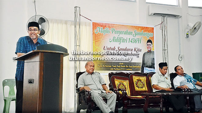 BANTUAN RAYA: Hasbi (kiri) pada majlis sumbangan raya kepada saudara baharu disaksikan Dr Rahman (dua kanan) semalam.