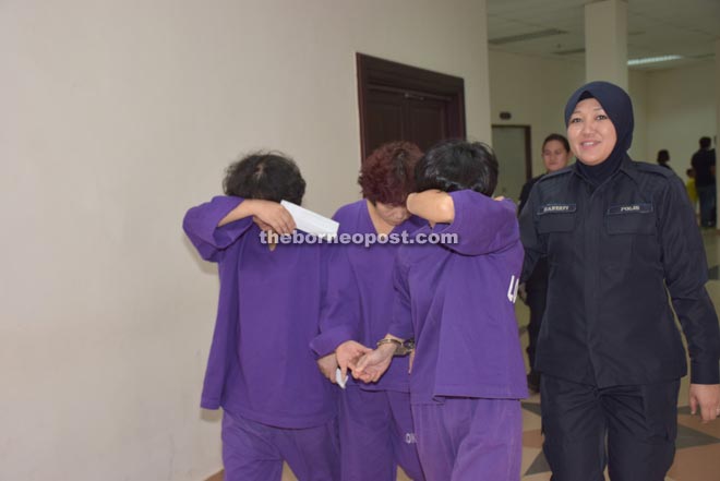 The three female accused being escorted to the courtroom by a policewoman.