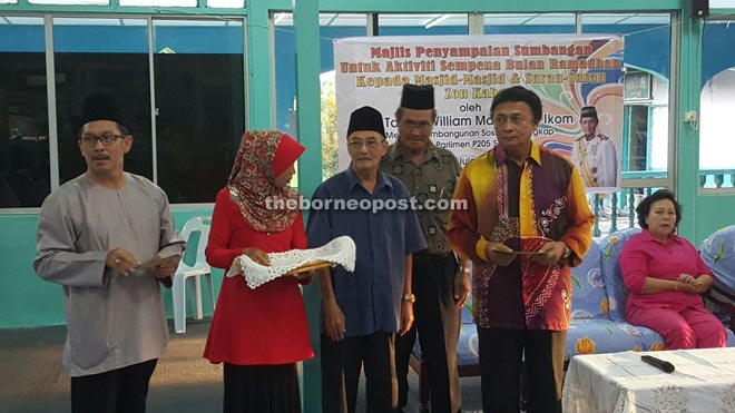 Mawan (right) and close aides ready to distribute government grants to mosques and surau in Kabong.