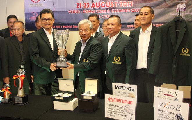 Masing (centre) presenting the challenge trophy to Zulkifli. On Masing’s left is Lau.