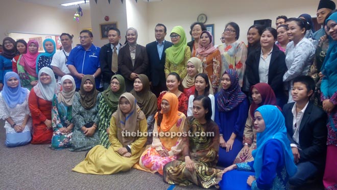 Fatimah (standing tenth left) and others at the Ramah Tamah Aidilfitri event.