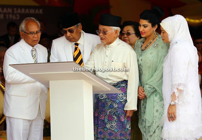 Taib (third right) signs the plaque to mark the 52nd anniversary of Sarawak’s independence, witnessed by (from left) Jabu, Adenan, Ragad and Jamilah. 