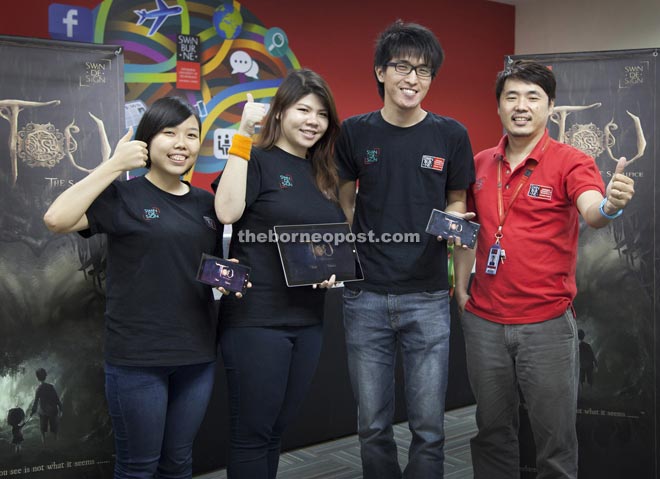 (From left) Sim, Wang, Chia and multimedia design lecturer John Hii showing Tou: The Sacrifice on their mobile phones.