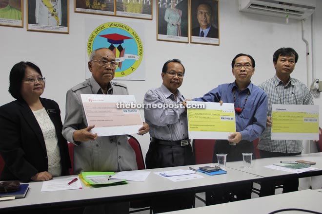 Dusit (centre) presents a RM5,000 mock cheque to Paul. Also seen with their mock cheques are Sidi (second left) and Richard (right). At left is Noelle.