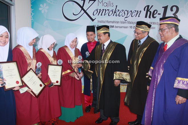 Jamil Khir (third right), together with Putit and Othman (right and second right, respectively) talking to some of the award winners after the graduation ceremony