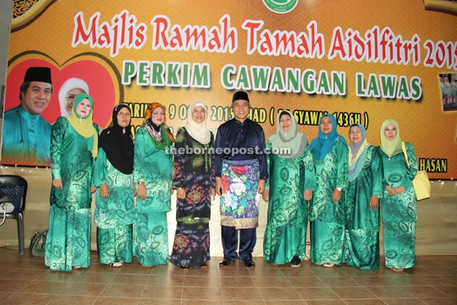 Awang Tengah (centre) and Dayang Morliah (fourth left) pose with the exco members of Perkim Lawas during their Hari Raya gathering.