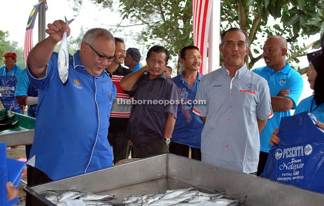 Zaiedy showing a fish sold at a reasonable price at the fishermen market in Kidurong.