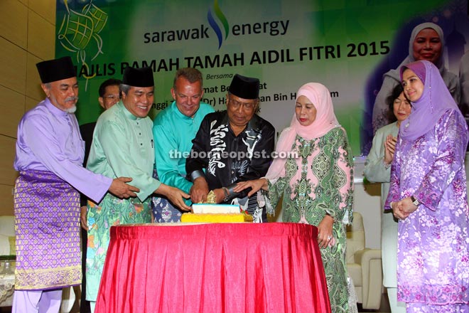 Adenan (fourth from left) cutting a ‘pulut kuning’ with (from left) Asfia, Awang Tengah, Sjotveit and Jamilah. — Photo by Chimon Upon