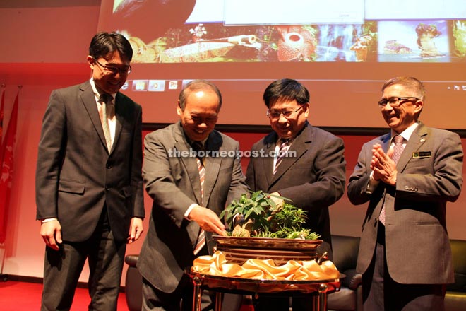 Nansian (second left) places plants in a mini garden when officiating at the opening of the workshop. From left are Dr Jason Hon, Malajum and Peter Sawal. 