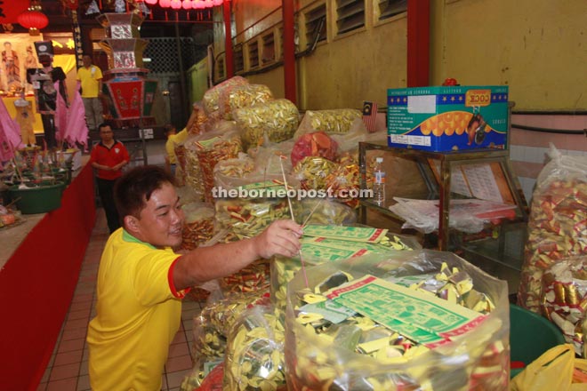 A volunteer prepares the joss papers for the festival.