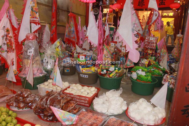 Offerings of food being laid out next to hampers for the ‘Qiang Gu’.
