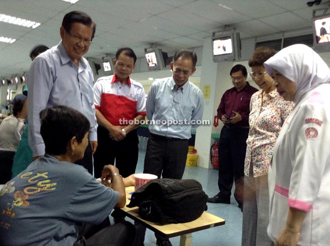(From left) Lee, Jurip, Kassim and others visit a patient whose treatment is being subsidised by the Ministry of Health.
