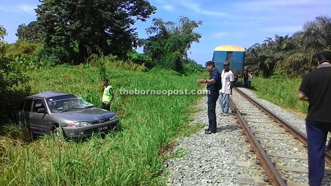 Police carrying out investigation at the scene after the passenger train collided with a Proton Wira at Jalan Mawau, Kampung Pimping in Membakut, Beaufort.