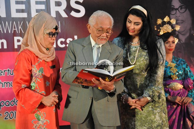 Taib (centre) going through the ‘Sarawak Women In Politics: The Pioneers’ book that was launched yesterday. With him are Fatimah (left) and Ragad.