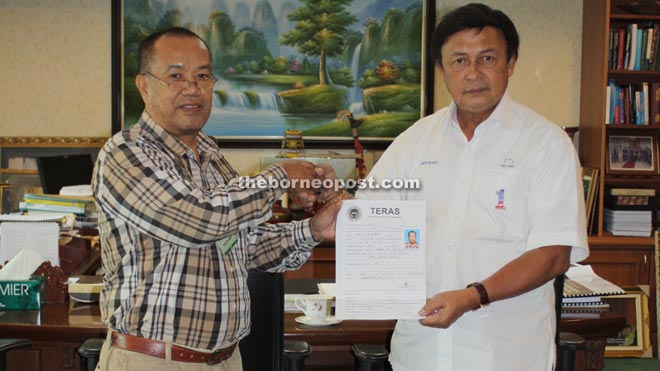 Idris (left) handing over his Teras membership application form to Mawan. — Photo by Churchill Edward