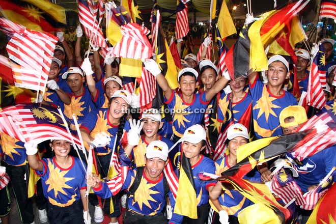 Students wave the Jalur Gemilang and Sarawak flags during the Malaysia Day celebration in Sematan. — All photos by Chimon Upon