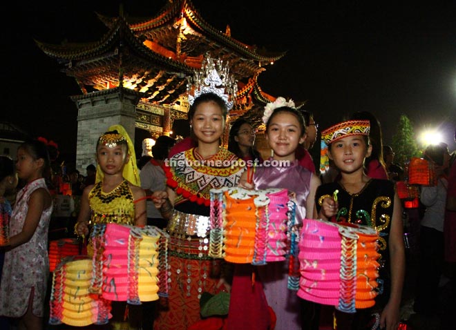 Children in traditional costumes, happily displaying their lanterns before taking part in the procession.