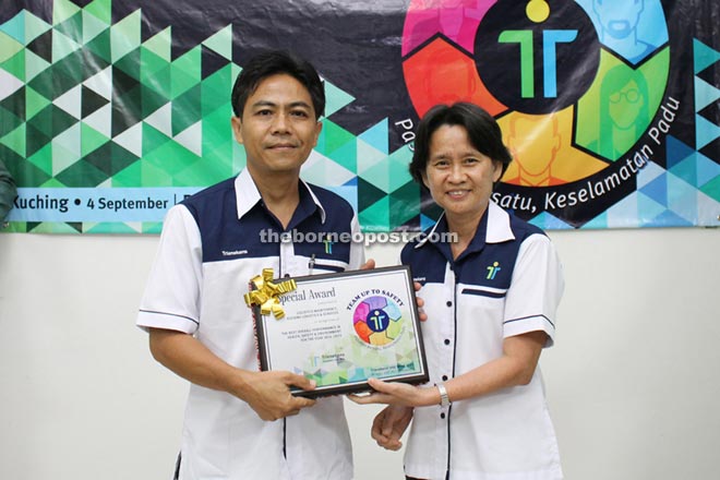 Kuching Logistics Maintenance Department’s manager Behui Longe (left) receives the ‘Best Overall Performance in HSE Award’ for the department from general manager of projects Alice Lee.  