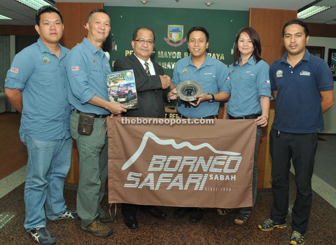 Abidin (third left) receiving a memento from Faez while members of the organising committee look on.