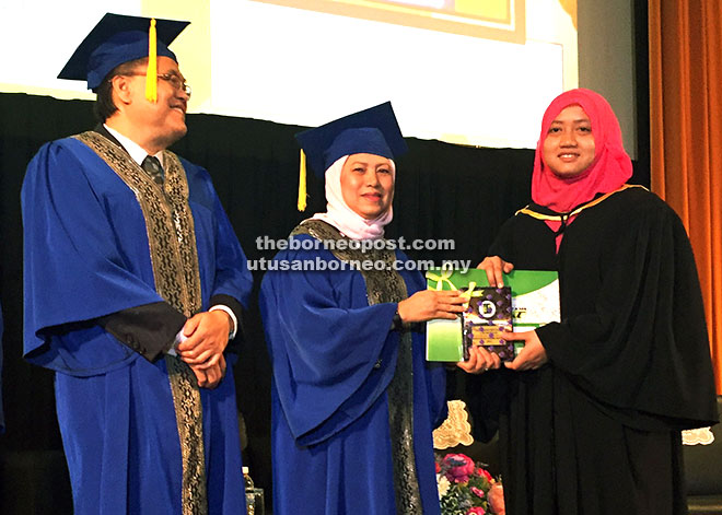 TAHNIAH: Nancy (tengah) menyampaikan sijil dan hadiah kepada penerima Anugerah Tokoh Aspuri 2015 SMTS Nurul Shafika Dainis (kanan) pada Majlis Hari Anugerah Kualiti 2015 Sekolah Menengah Teknik Sejingkat (SMTS), di Auditorium Pustaka Negeri Sarawak, di Kuching semalam. 