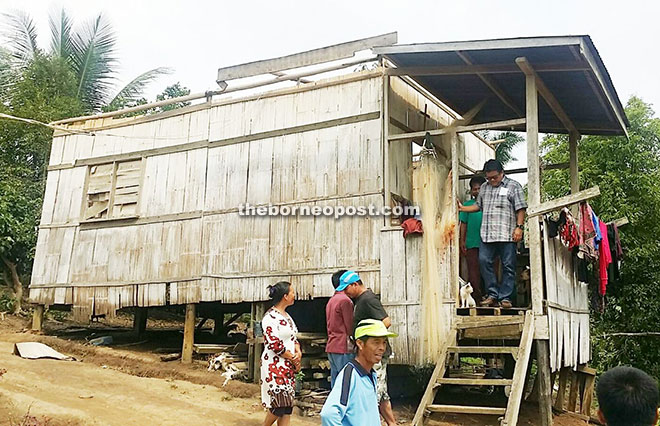 Ellron inspecting the condition of a house in Kampung Simpang Empat which had its roof blown off by the wind. 