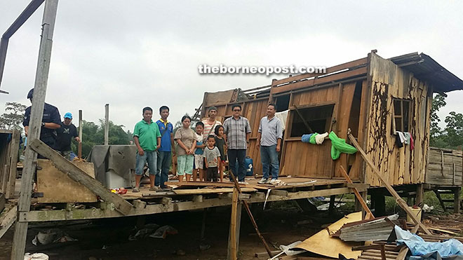 Ellron with the owner of a house that was damaged by wind at Kampung Simpang Empat.