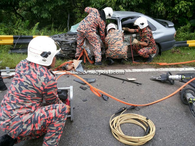 Firemen working to free the trapped victim.