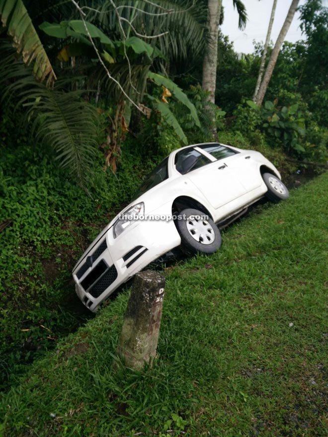 The car in a ditch after veering off the road near Kampung Pujut Padang Kerbau.