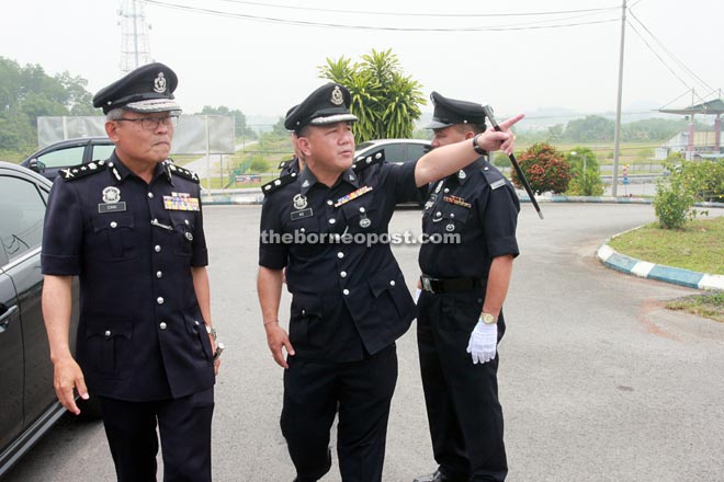 Ng (right) points at something as he greets Chai on his arrival at Padawan district police headquarters yesterday.