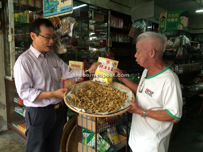 Trader Peter Wong (right) tells Kiang Chiok about the efficacy of his herbal products. 