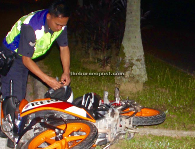 A policeman checks Stewart’s  motorcycle after the fatal accident.