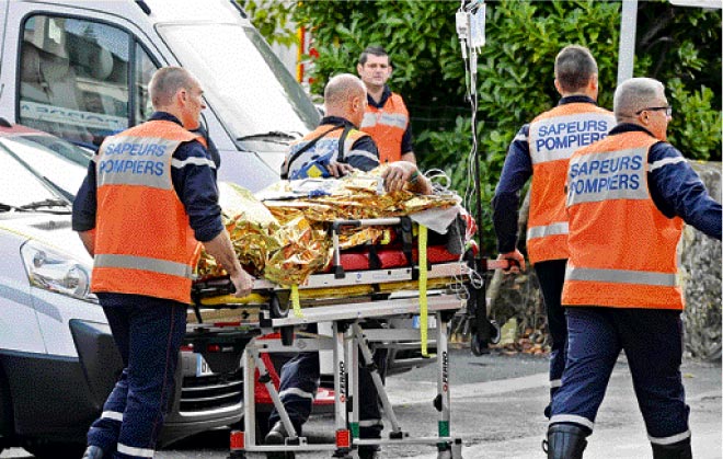 Emergency services personnel take away an injured person from the site of a collision in Puisseguin, near Libourne, southwestern France. — AFP photo