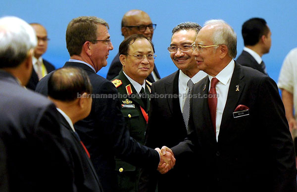 Prime Minister Datuk Seri Najib Tun Razak (right) greets Carter upon his arrival during the meeting while Hishammuddin (second right) looks on. — Bernama photo