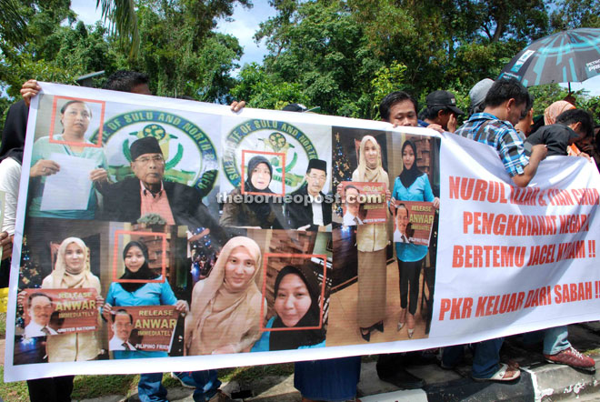 Protesters carrying banners condemning Nurul Izzah and Tian Chua for meeting Jacel Kiram in Manila.